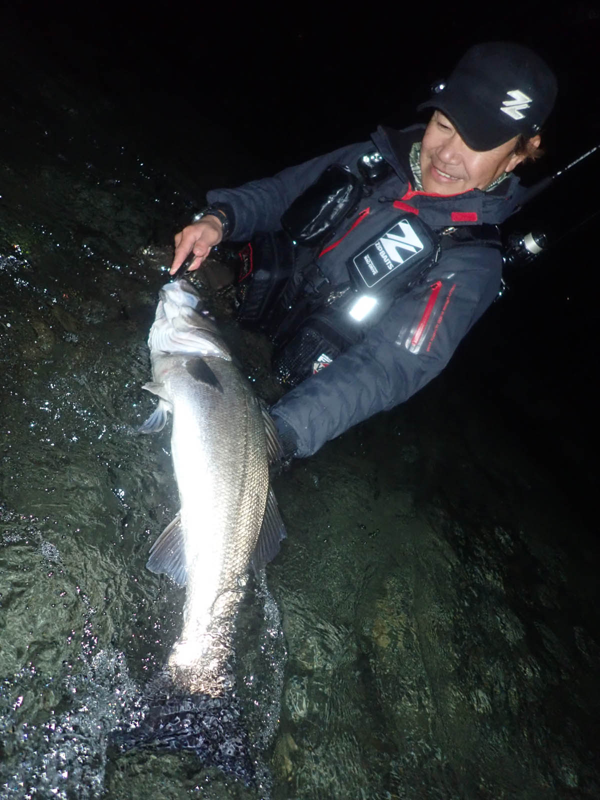 河川で釣れたシーバスを持つ浅川和治さん