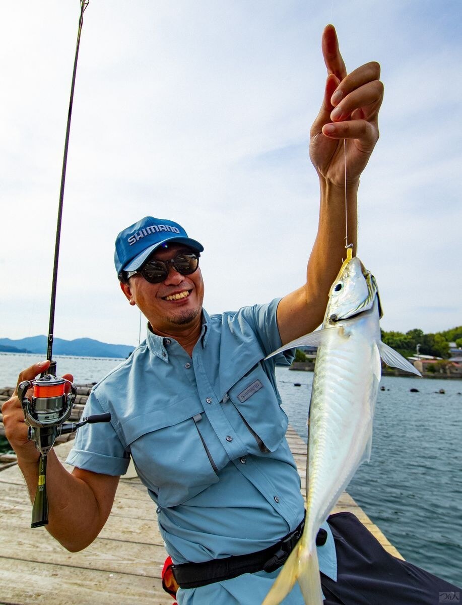 愛南町の御荘湾で釣れたアジを掲げる丹羽さん。むっちりとした体型が特徴だ