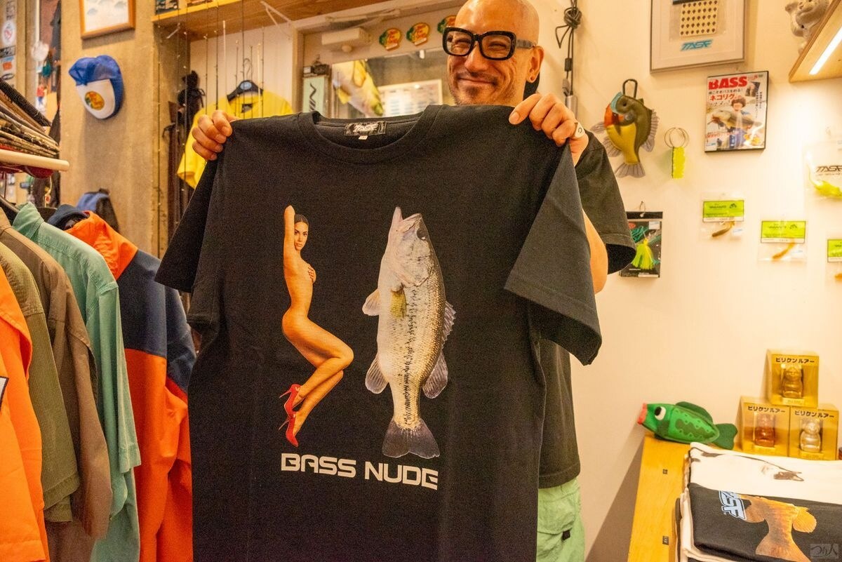 「BASS NUDE」のTシャツを広げる店のスタッフ