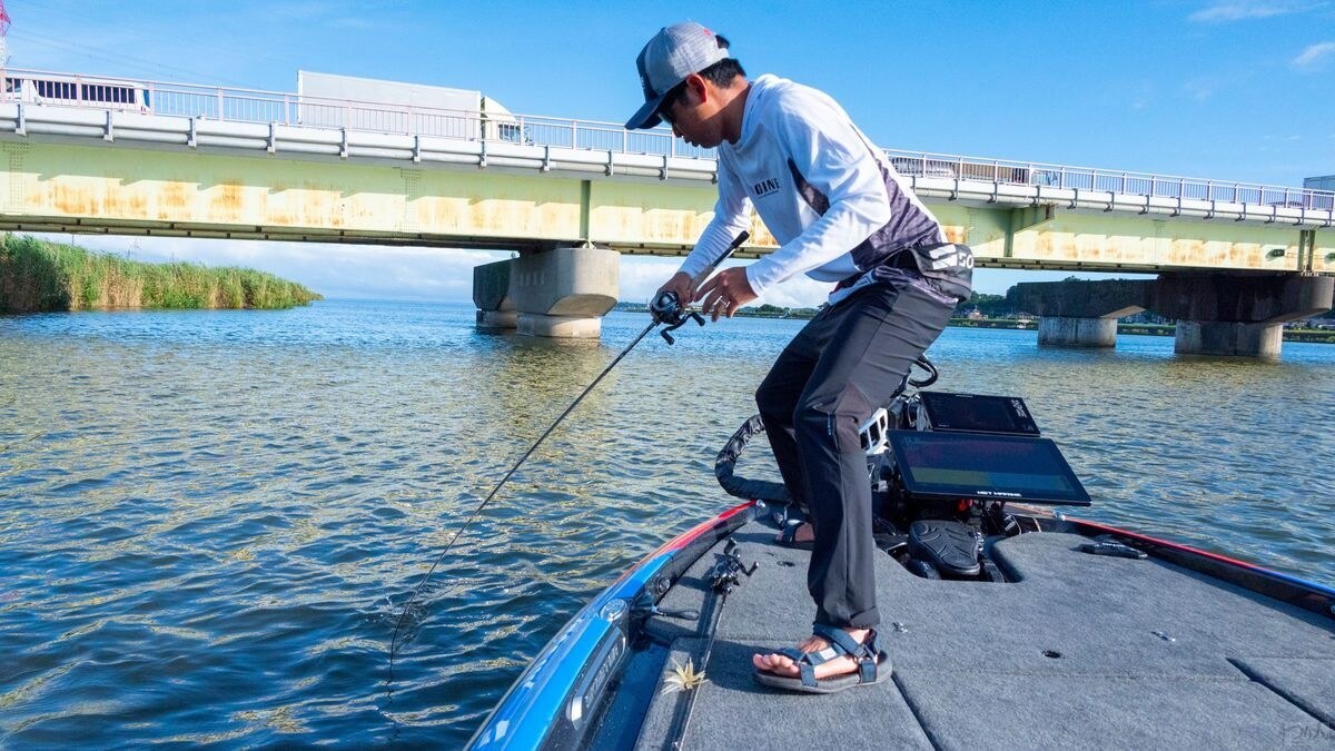 ボートの上でバスとやり取りする今泉拓哉さん
