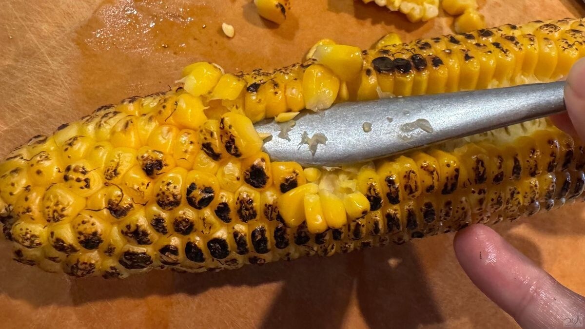 焼いたトウモロコシから実を外す