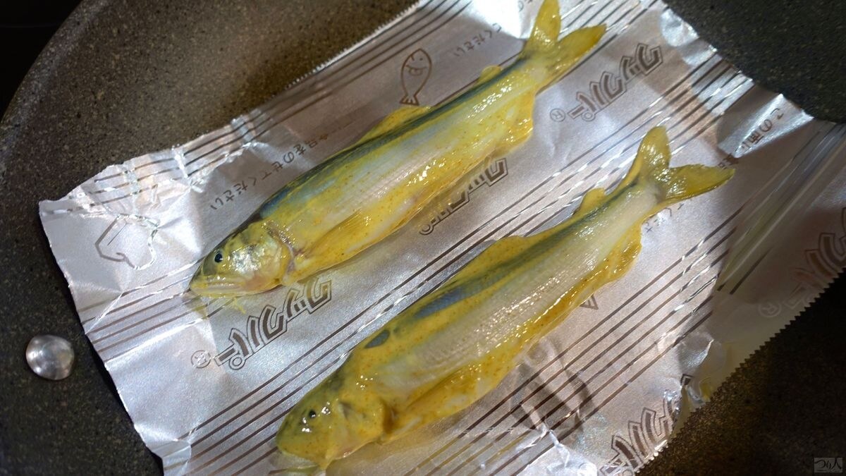 魚焼きシートを敷いたフライパンに並べたアユ