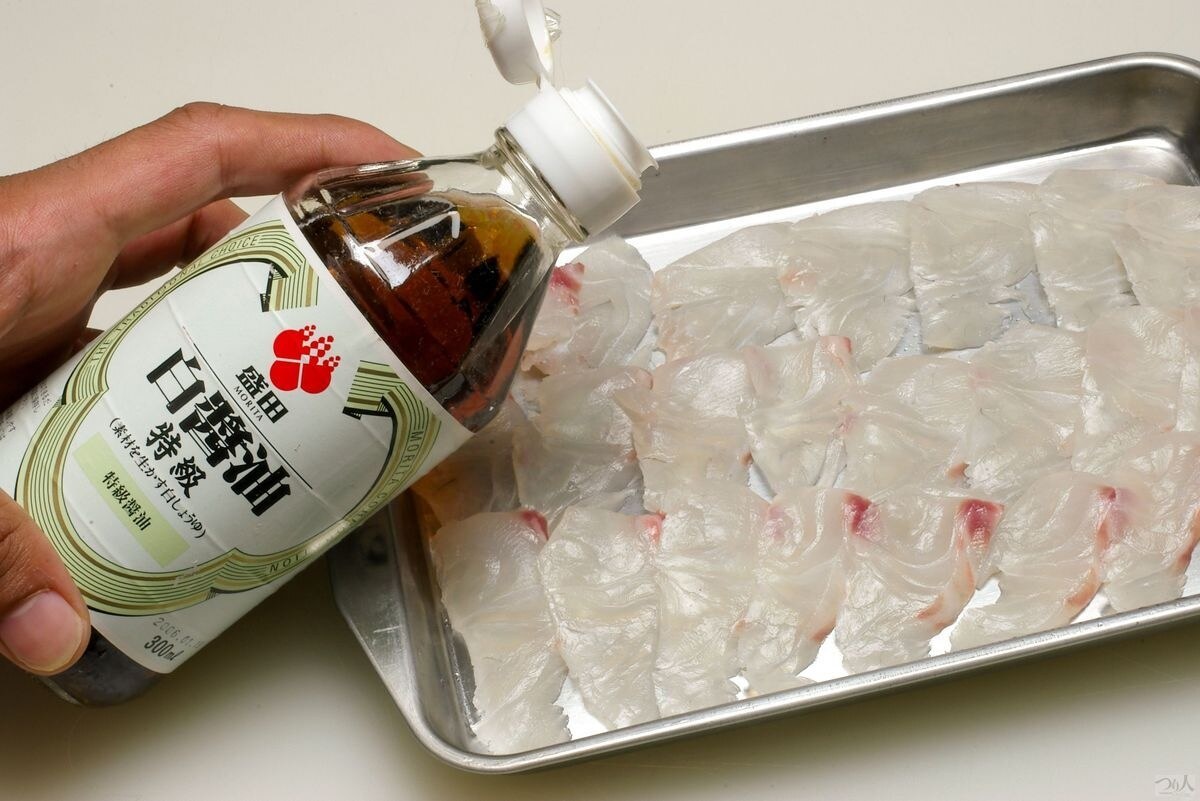 マダイの身は薄めのそぎ切りにし、白醤油少々を垂らして5～10分ほど味を含ませて漬け刺しに。中華がゆに漬け刺しとともに揚げ皮、香菜、万能ネギ、松の実を散らして召し上がれ