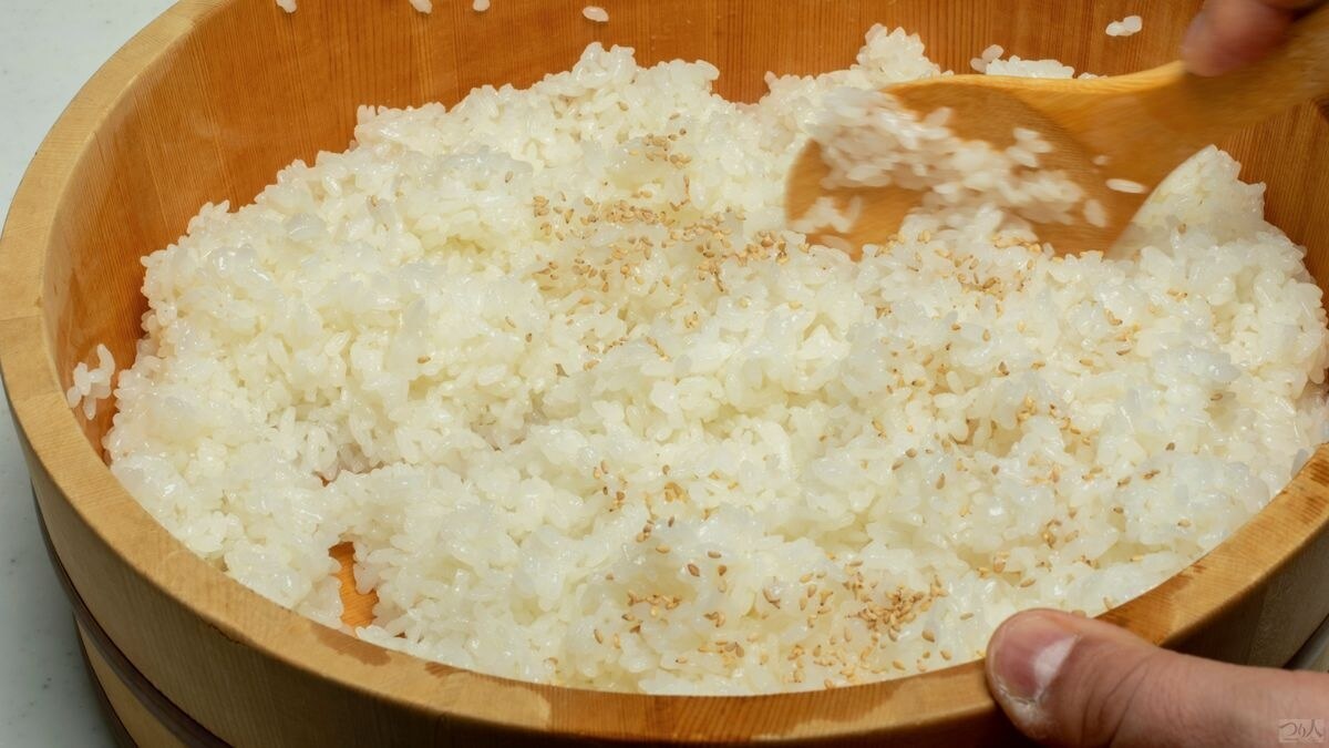 炊き立ての飯を木製桶の盤台に広げ、指定分量の寿司酢とともにコクを出す少量の魚醤（米4合に対し小さじ1.5）を合わせ、適量の白ゴマを振って寿司飯を作り冷ます