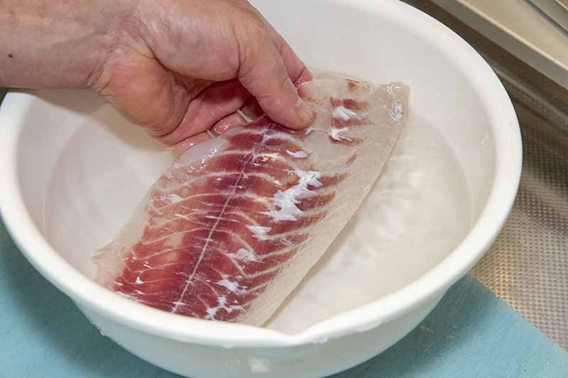 クロダイの捌き方 手順18：3%の塩水（水1リットルに塩30g）に10分くらい浸けて臭みの原因である身の水分