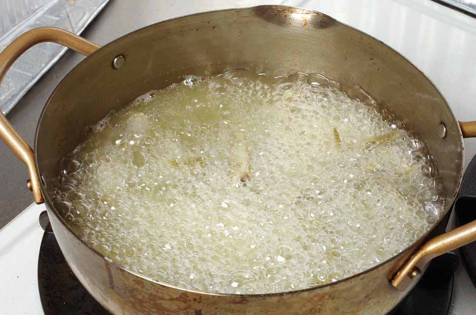 3.水分が飛ぶと泡が減って小さくなり、ハゼに火が通って油の表面に浮いてくる。軽くハゼをほぐす感じで菜ばしを入れる